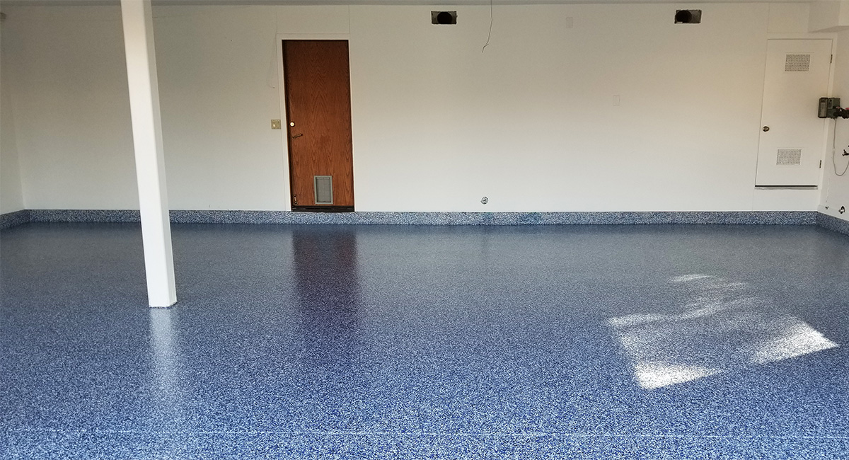 Interior view of garage with new blue-grey epoxy flooring set up by our Oak Park garage floor contractors.