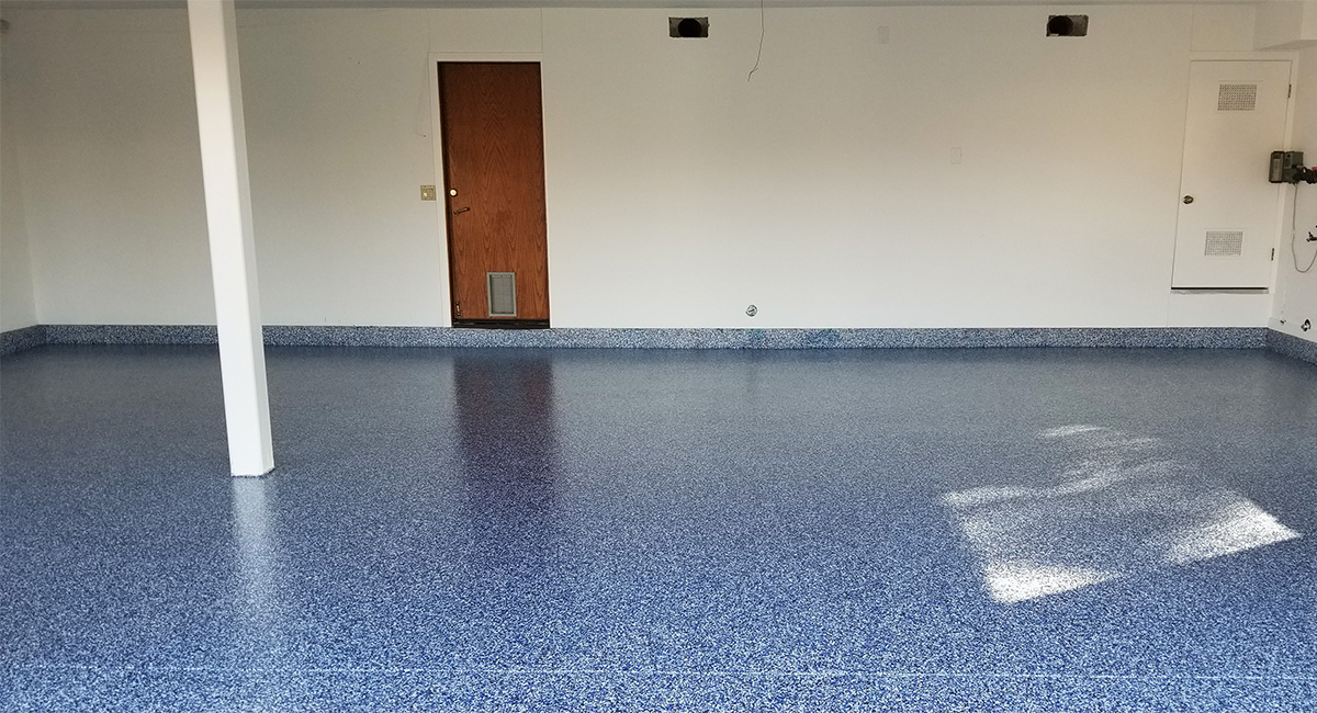 Interior view of garage with new blue-grey epoxy flooring set up by our Thousand Oaks garage floor contractors.